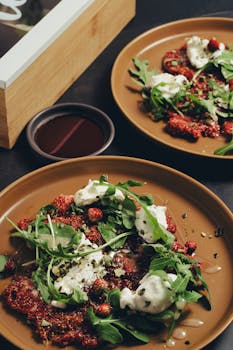 A savory arugula and beet salad topped with cheese on ceramic plates.
