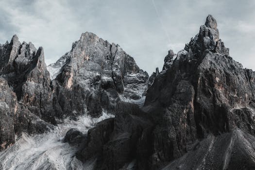 Dramatic rock formations of a rugged mountain range under a moody sky, exemplifying natural beauty.