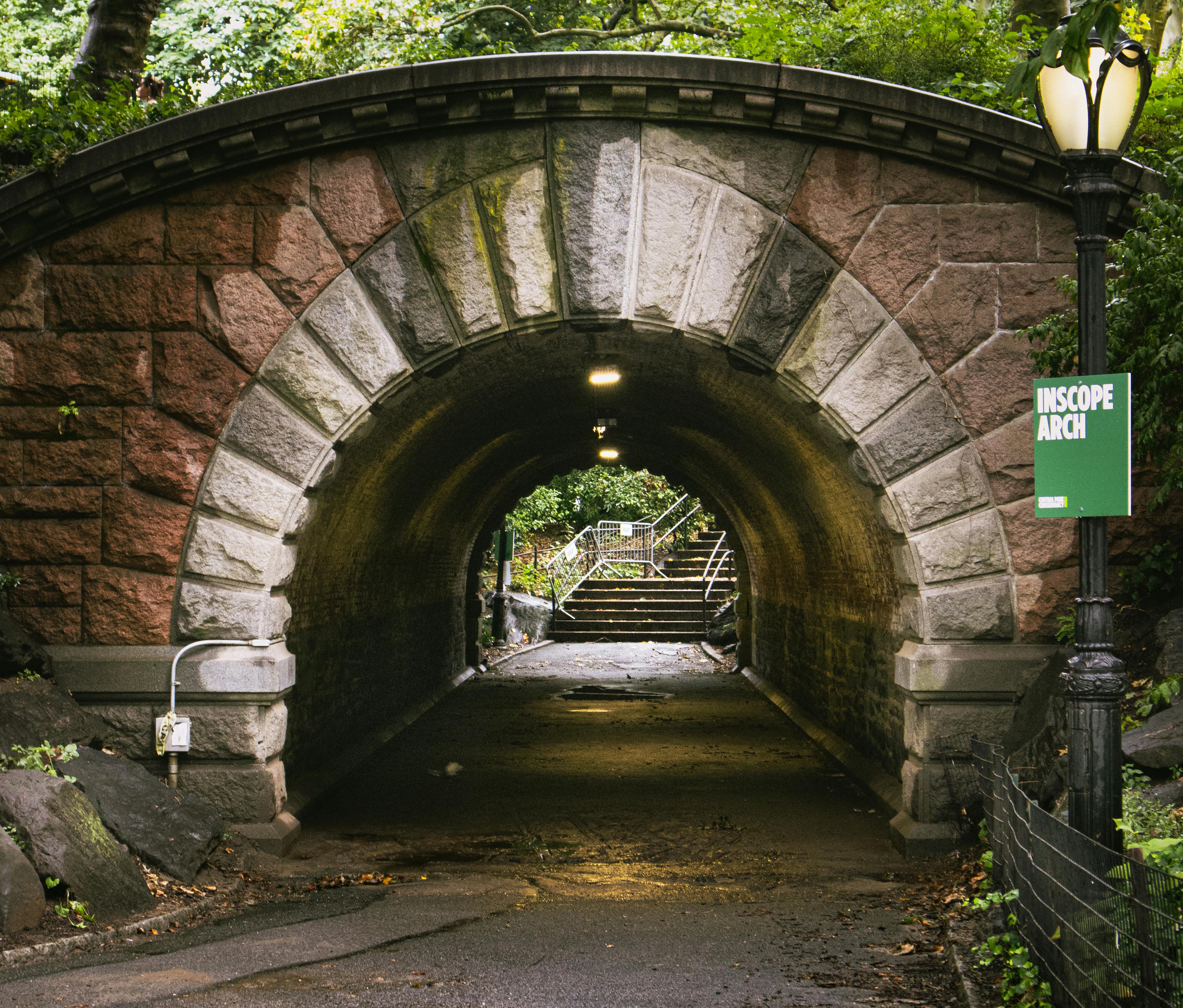 A serene view through Inscope Arch in Central Park, New York City, captured on a tranquil day.