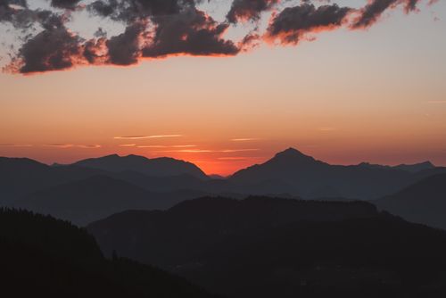 Free Breathtaking view of the mountains silhouetted against a dramatic sunset sky. Stock Photo