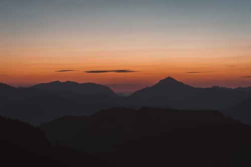 Free Beautiful silhouette of mountains during a stunning sunset with vibrant sky colors. Stock Photo