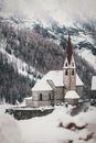 这座风景如画的教堂坐落在白雪覆盖的山地景观中，是冬季主题的理想选择