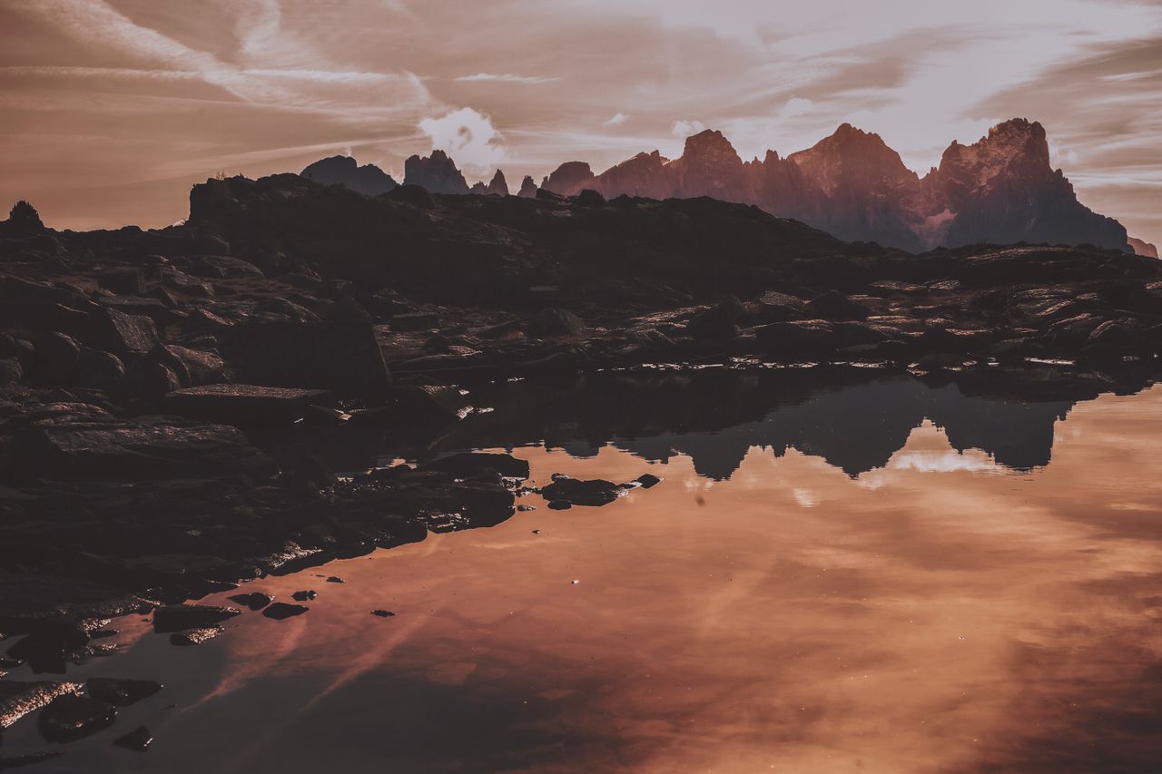 breathtaking sunset over rocky mountains with a tranquil water reflect