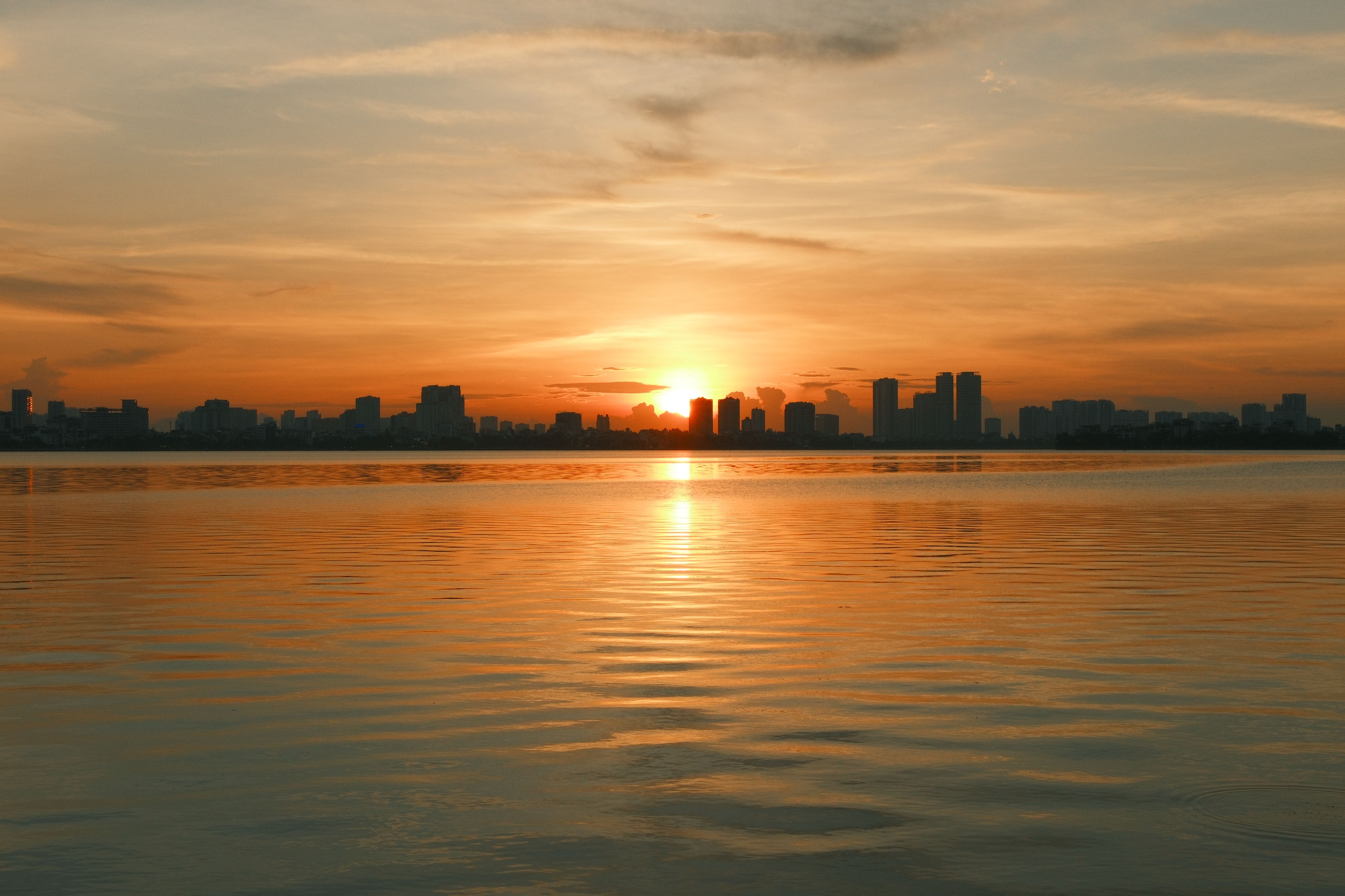 Dramatic Skyline Sunset with Reflective Water · Free Stock Photo