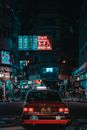 香港九龙的夜间街景充满活力，霓虹灯招牌和出租车点缀其中