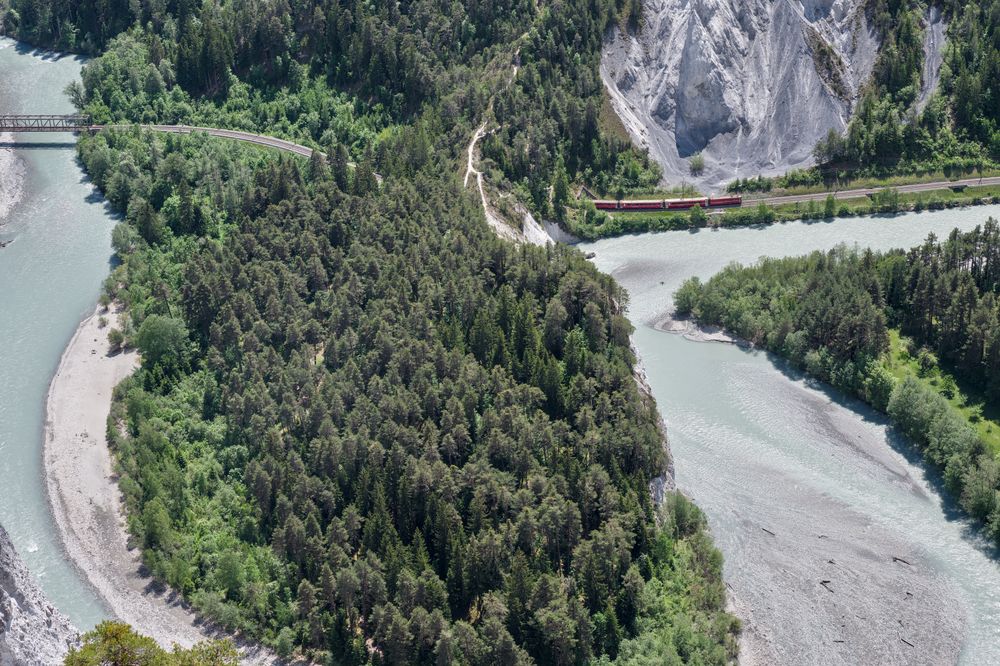Vedere aeriană a defileului Rinului cu un tren traversând peisajul