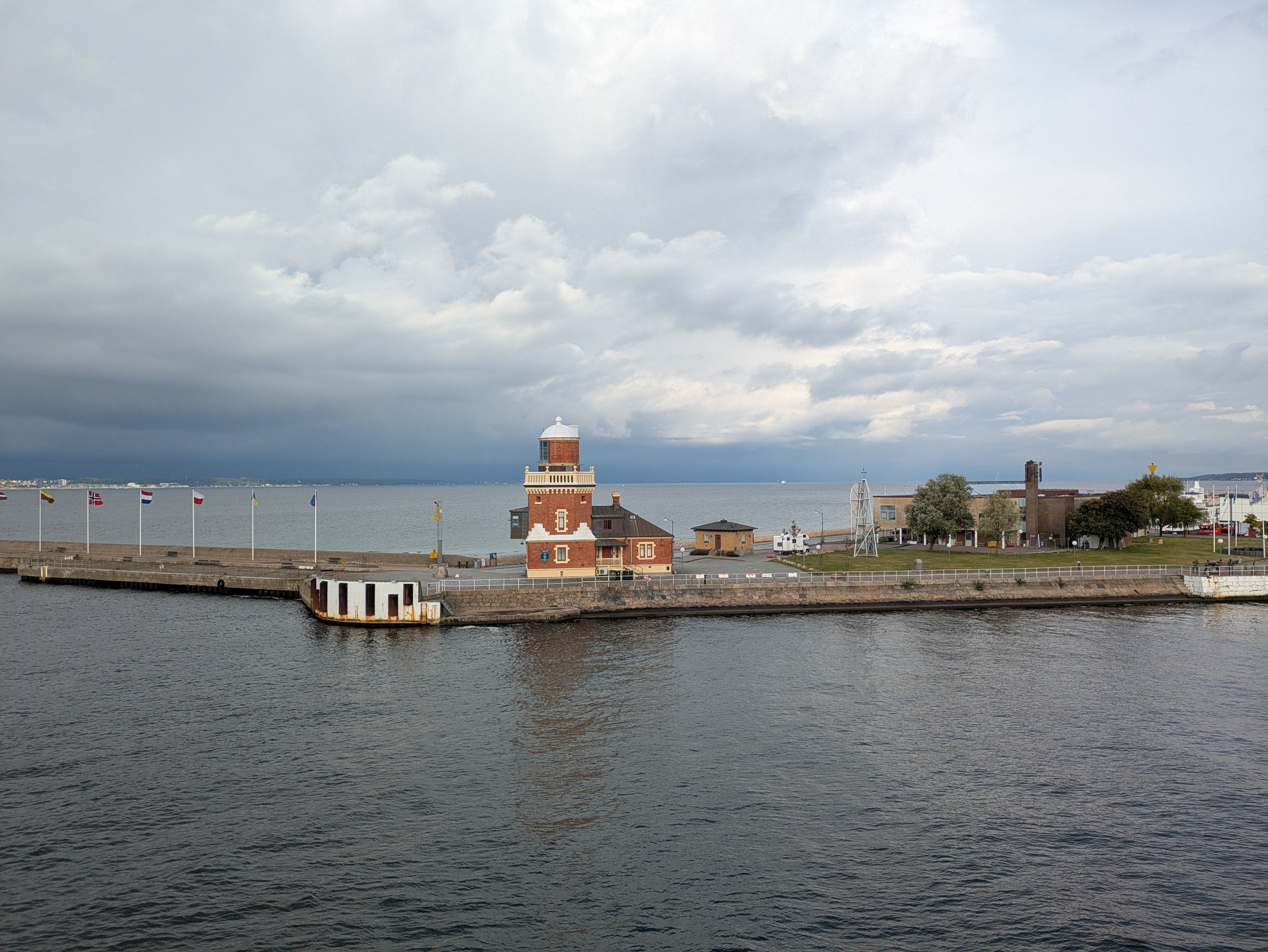 A picturesque view of the Helsingborg waterfront featuring a historic lighthouse against a cloudy sky.