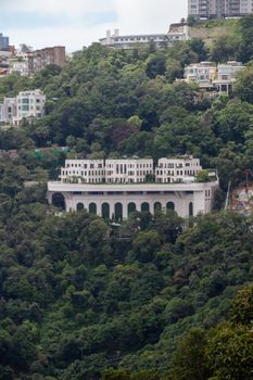 Discover a stunning luxury villa surrounded by lush greenery in the hills of Hong Kong.