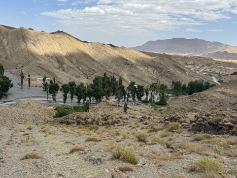 Stunning landscape of Dades Valley with trees and mountains under a partly cloudy sky in Morocco.