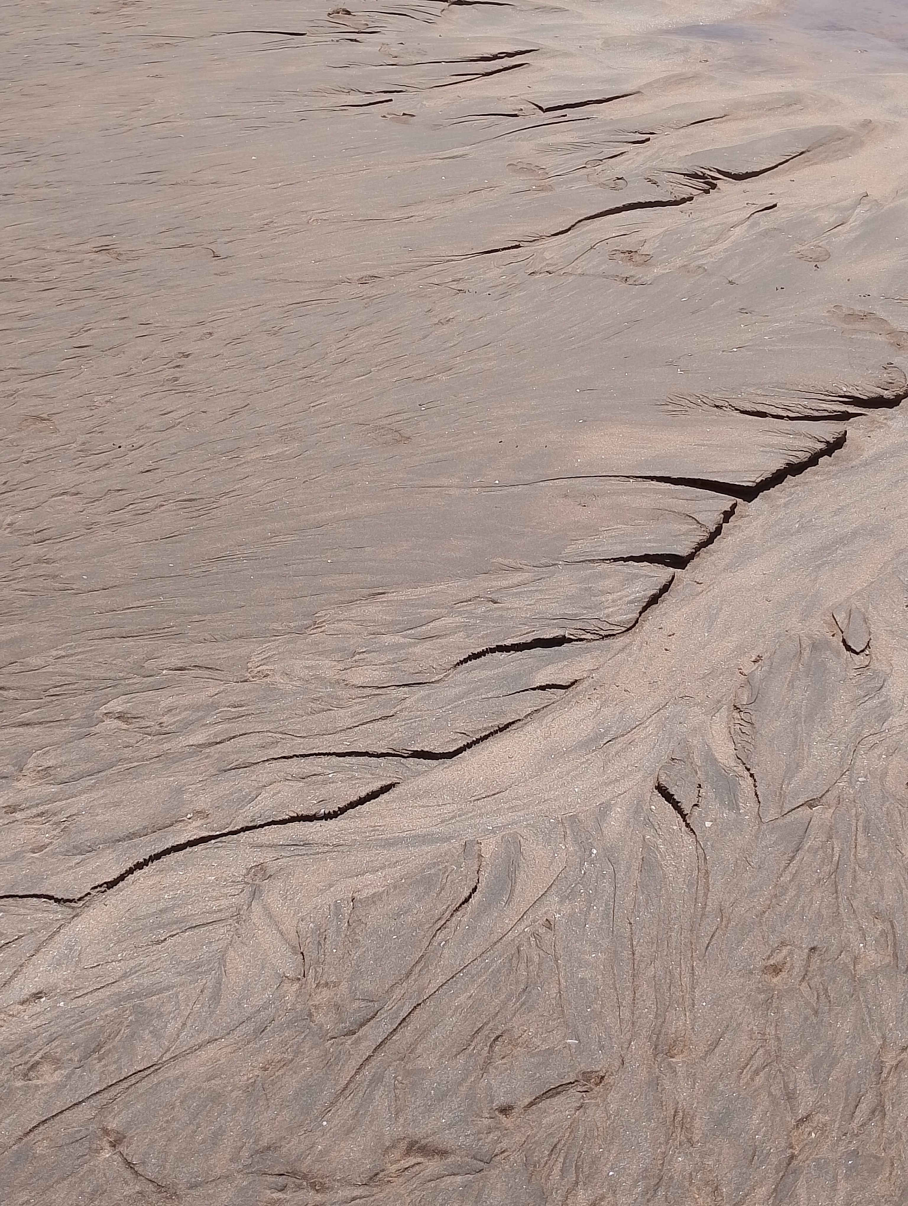 Intricate patterns formed by water erosion in beach sand, Casablanca, Morocco.