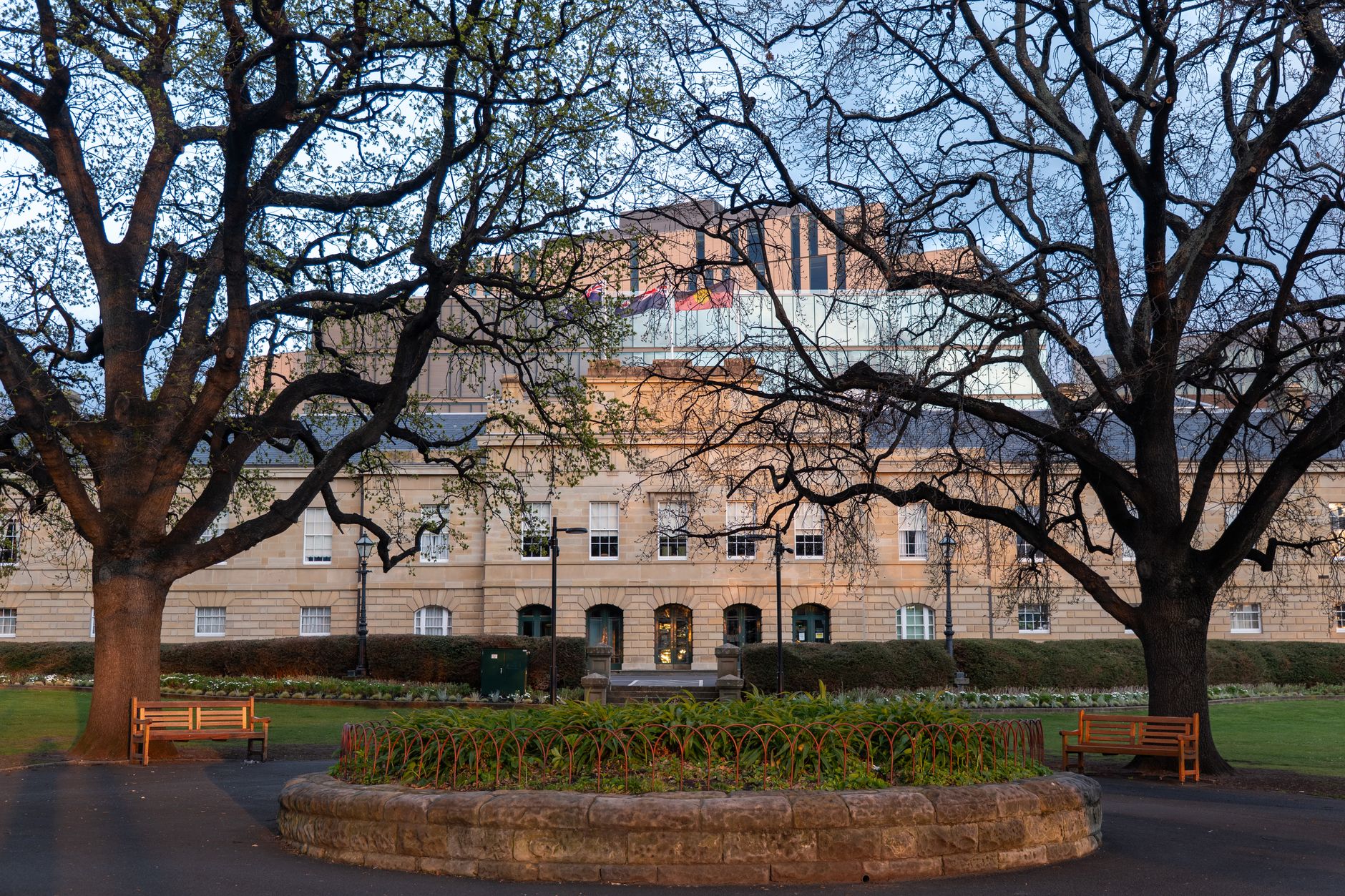 Historic Hobart Courthouse framed by trees in early morning light, Tasmania.