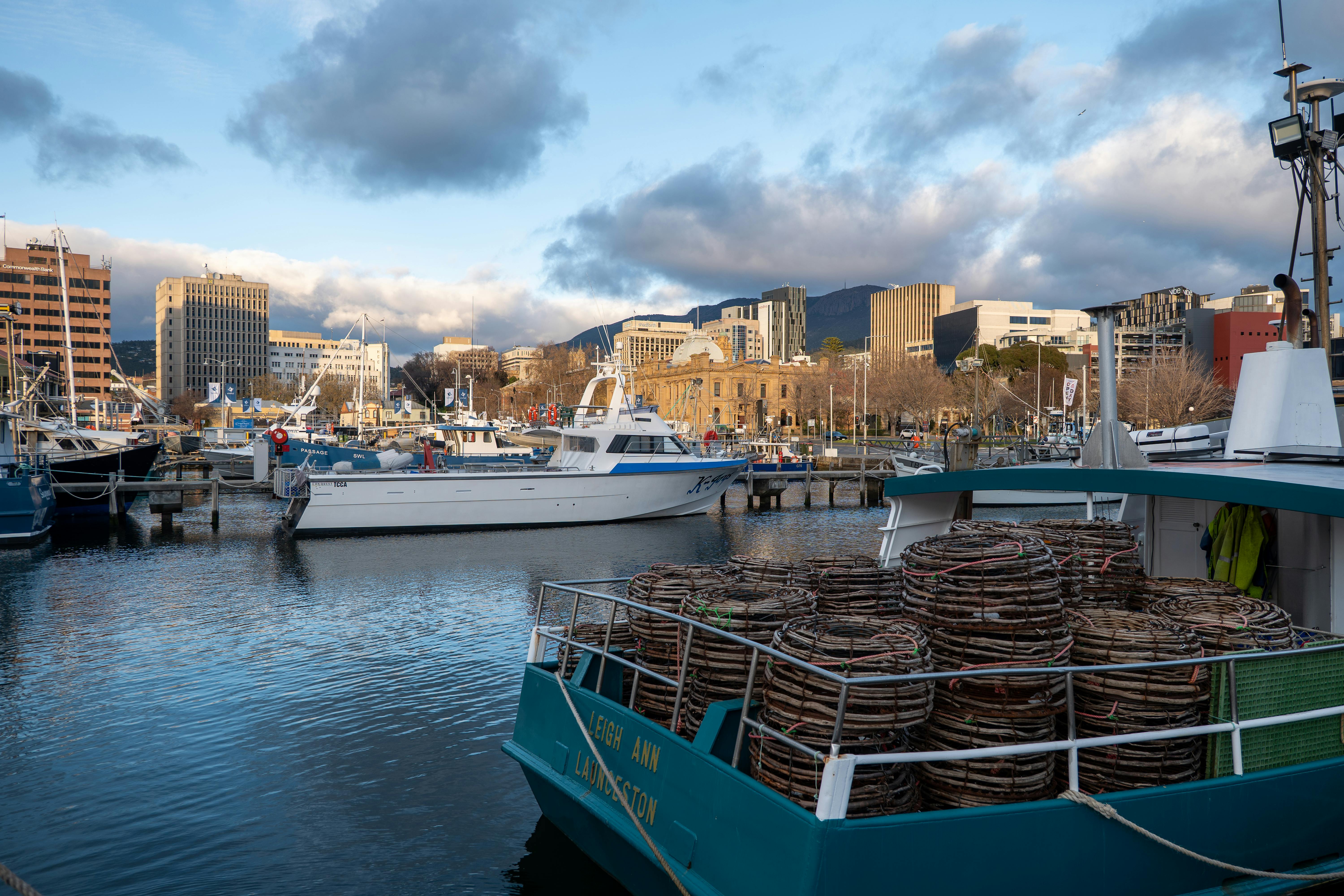 Beautiful evening scene at Hobart waterfront with fishing boats and cityscape, Tasmania.