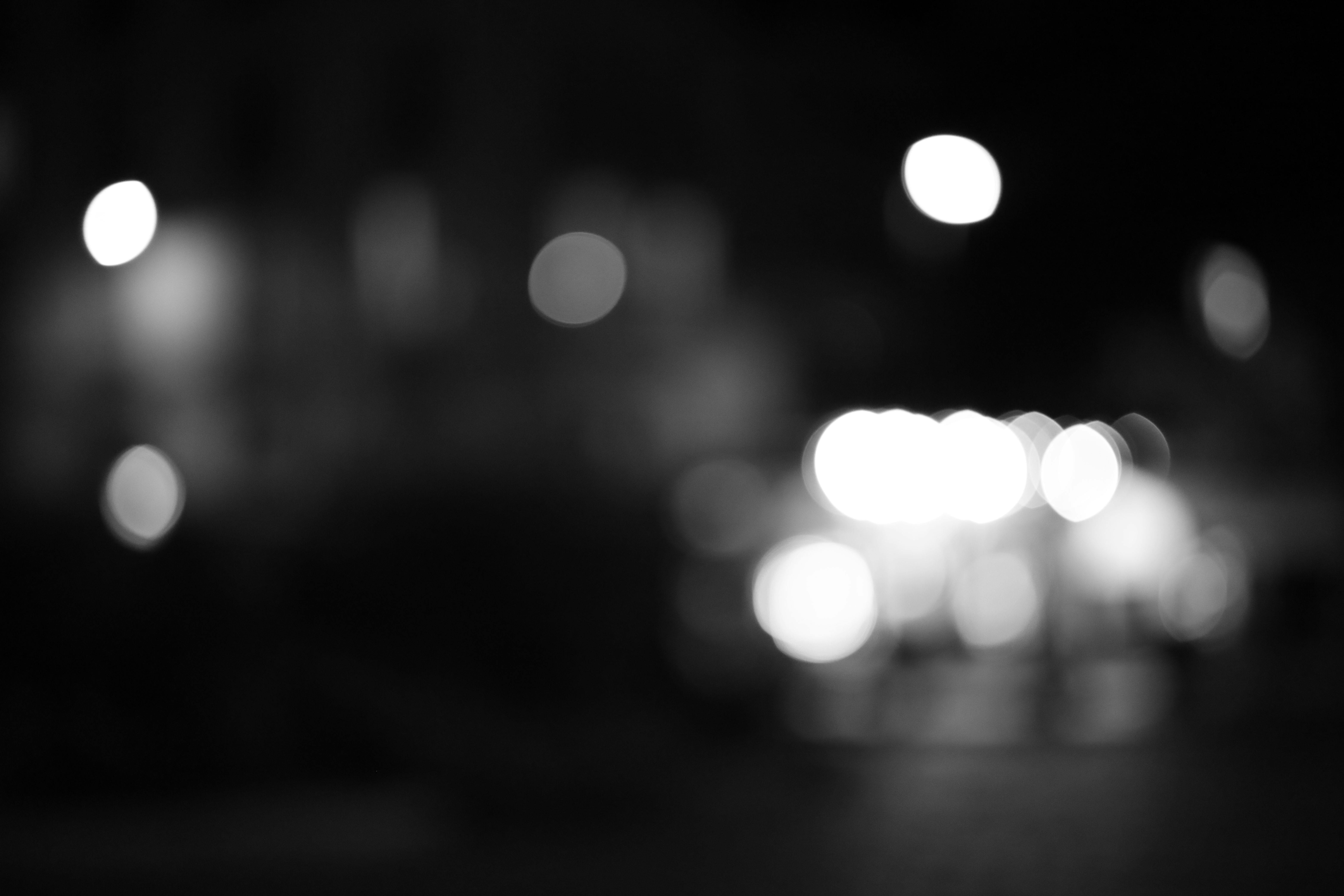 grátis Imagem em preto e branco capturando luzes desfocadas da cidade à noite em Paris, França. Foto profissional