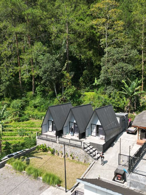 Free Aerial view of modern cabins in a lush forest setting, perfect for a nature retreat. Stock Photo