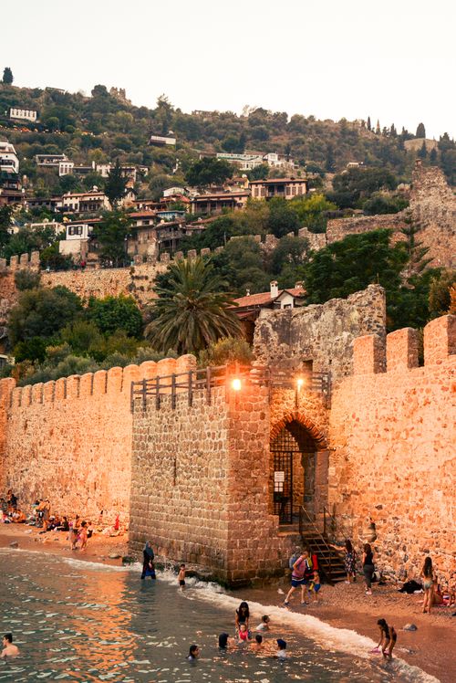 Free People enjoy a summer beach day at the historic walls of Alanya Castle, Turkey. Stock Photo