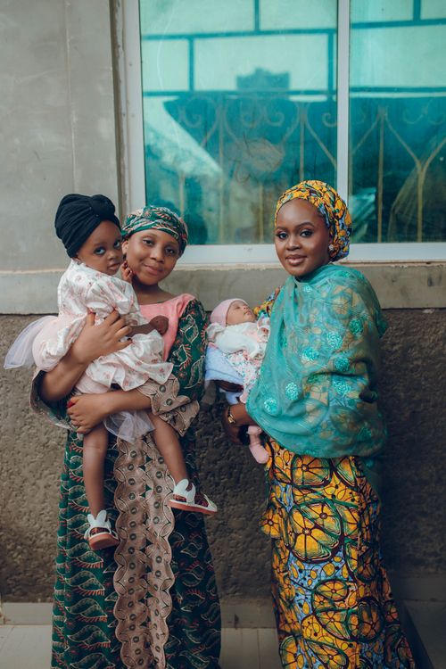 Free Portrait of Nigerian women in traditional attire holding children, showcasing cultural fashion. Stock Photo