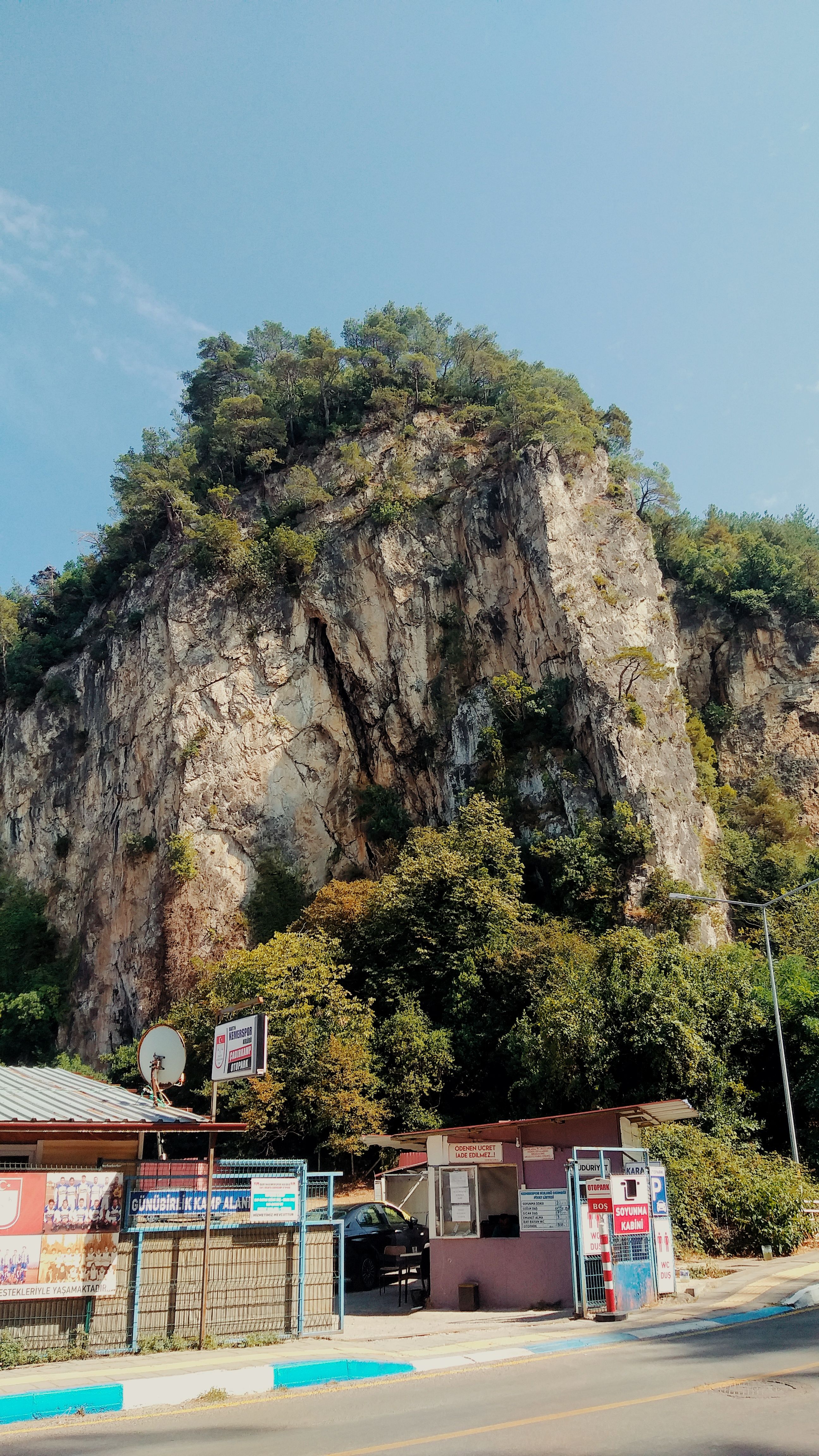 A stunning rocky cliff surrounded by greenery in Bartın, Türkiye, under a clear blue sky.