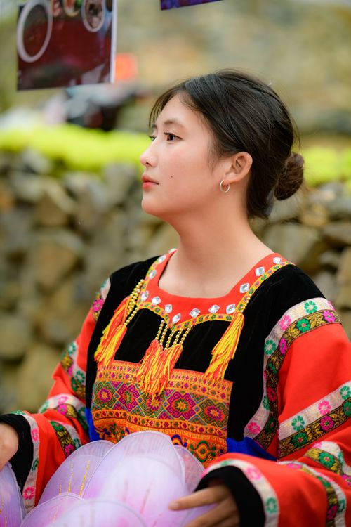 Free Young woman in traditional Asian attire outdoors with vibrant textiles. Stock Photo