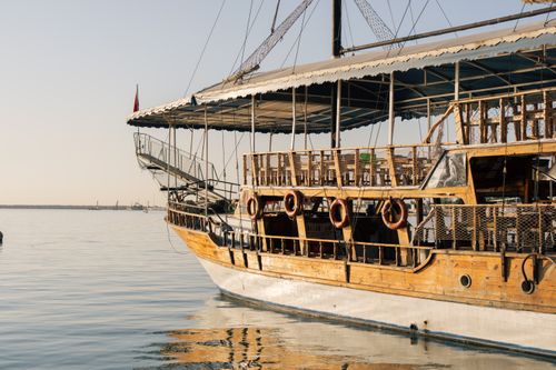 Free A traditional wooden boat docked at Mersin harbor in Türkiye, captured on a calm day. Stock Photo