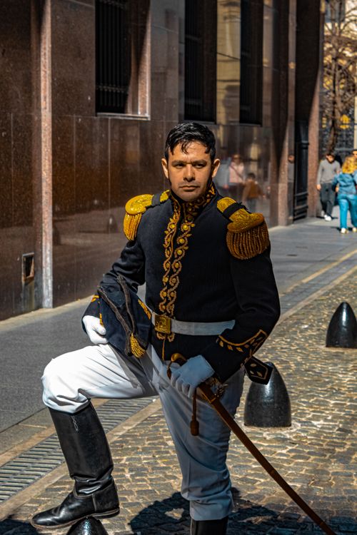 Free A powerful image of a soldier in a traditional uniform standing confidently on a city street. Stock Photo
