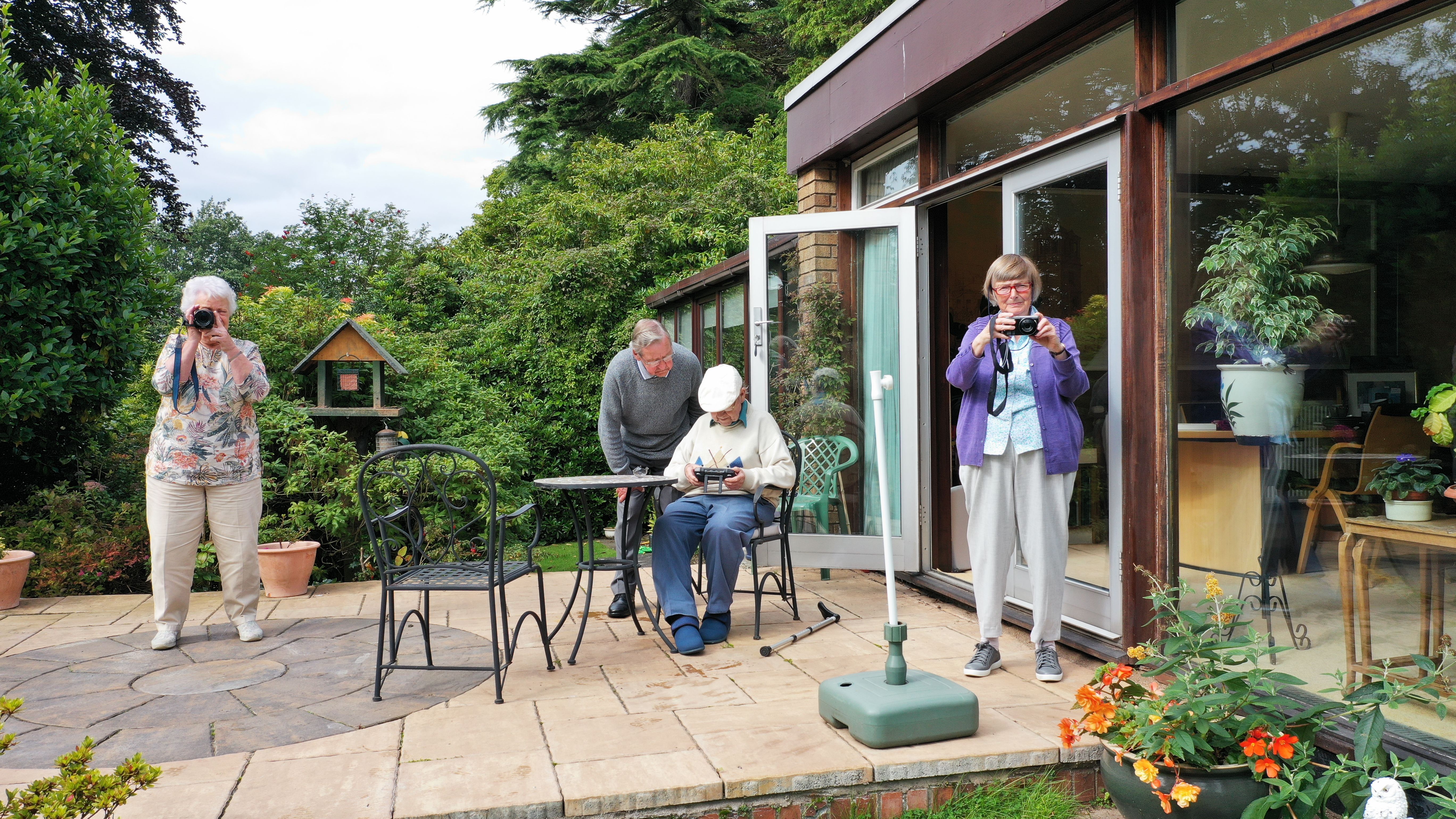 Retirees relaxing in a sunny community garden courtyard