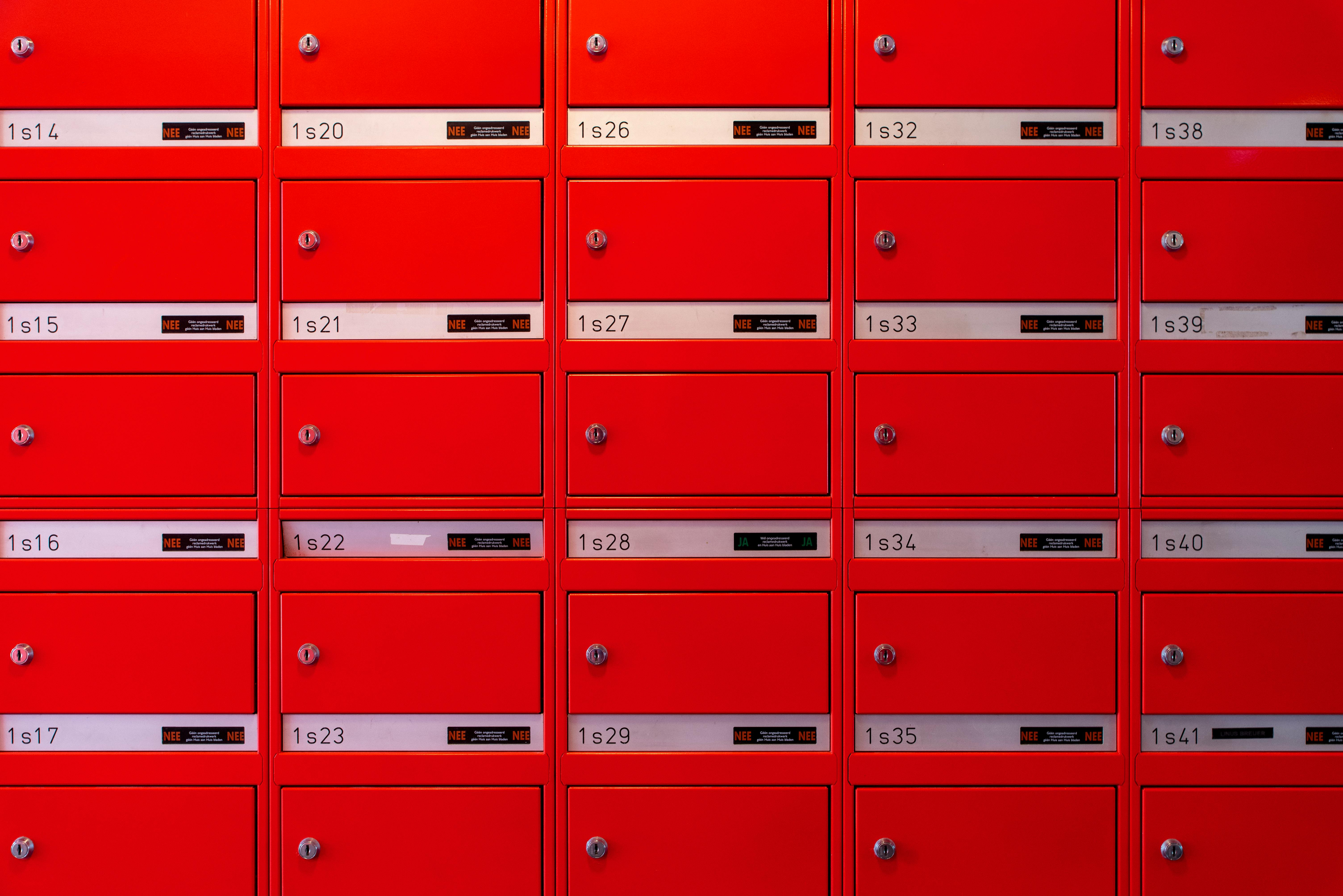 Vibrant red mailboxes arranged in a grid pattern, perfect for urban lifestyle visuals.