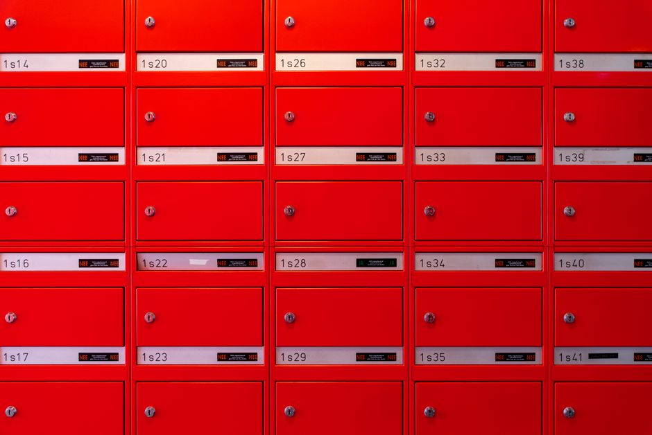 Vibrant red mailboxes arranged in a grid pattern, perfect for urban lifestyle visuals.