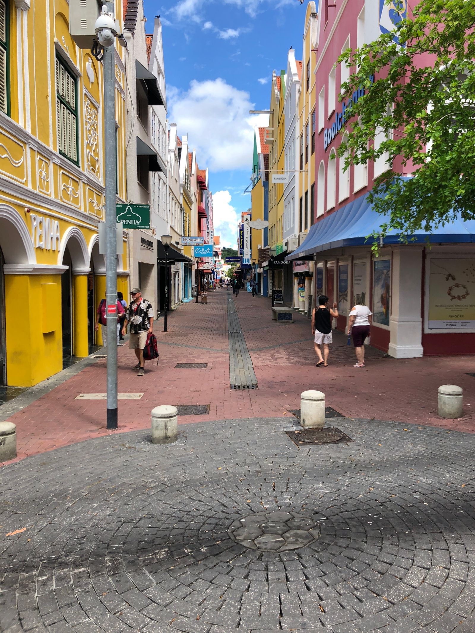 Walkable Willemstad street with colorful buildings, shops and pedestrians