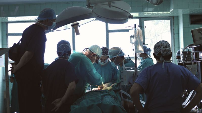 Medical team conducting surgery in a hospital setting with focused attention.