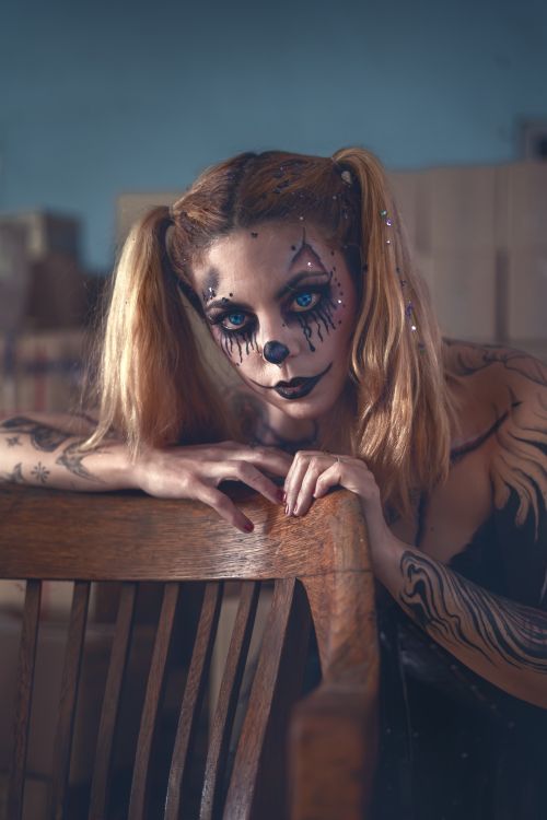 Free Captivating image of a woman with creative face paint and tattoos, exuding mystique and artistic expression. Stock Photo