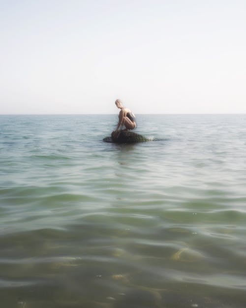 Vrouw Zittend Op Een Rots In De Zee