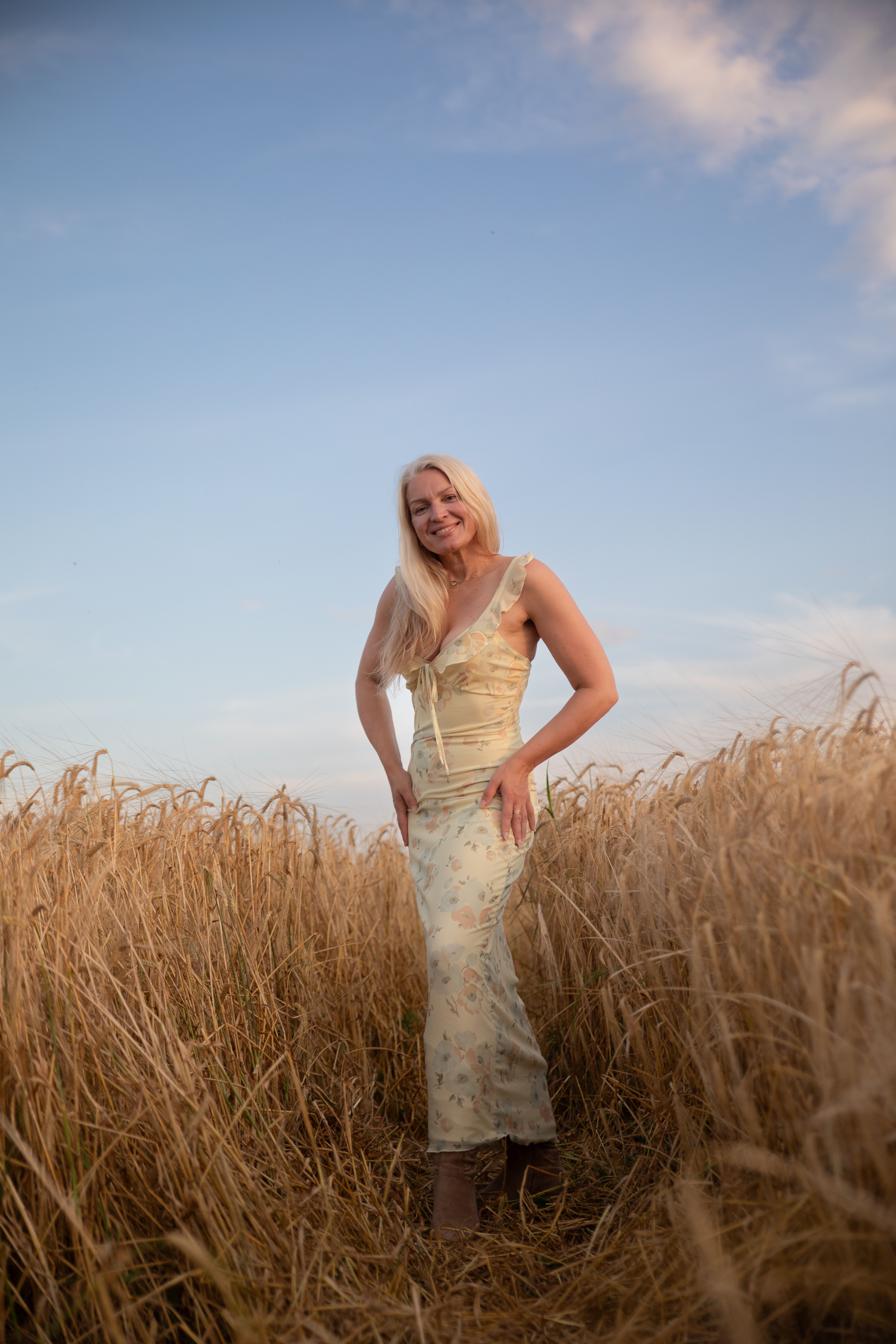 Woman Standing in a Wheat Field at Dusk · Free Stock Photo