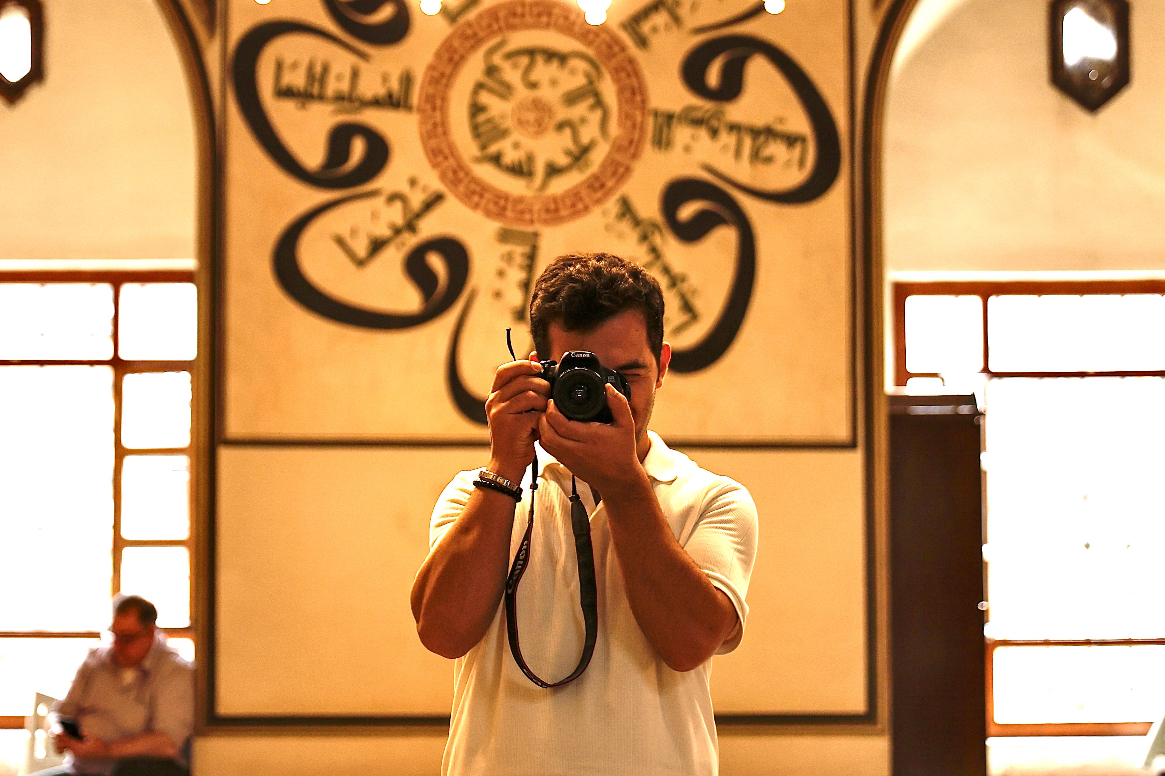 Photographer captures the beauty of mosque interior with intricate Islamic architecture.