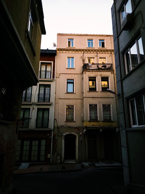 Free Quiet urban alley with tall buildings, soft evening light casting shadows. Stock Photo