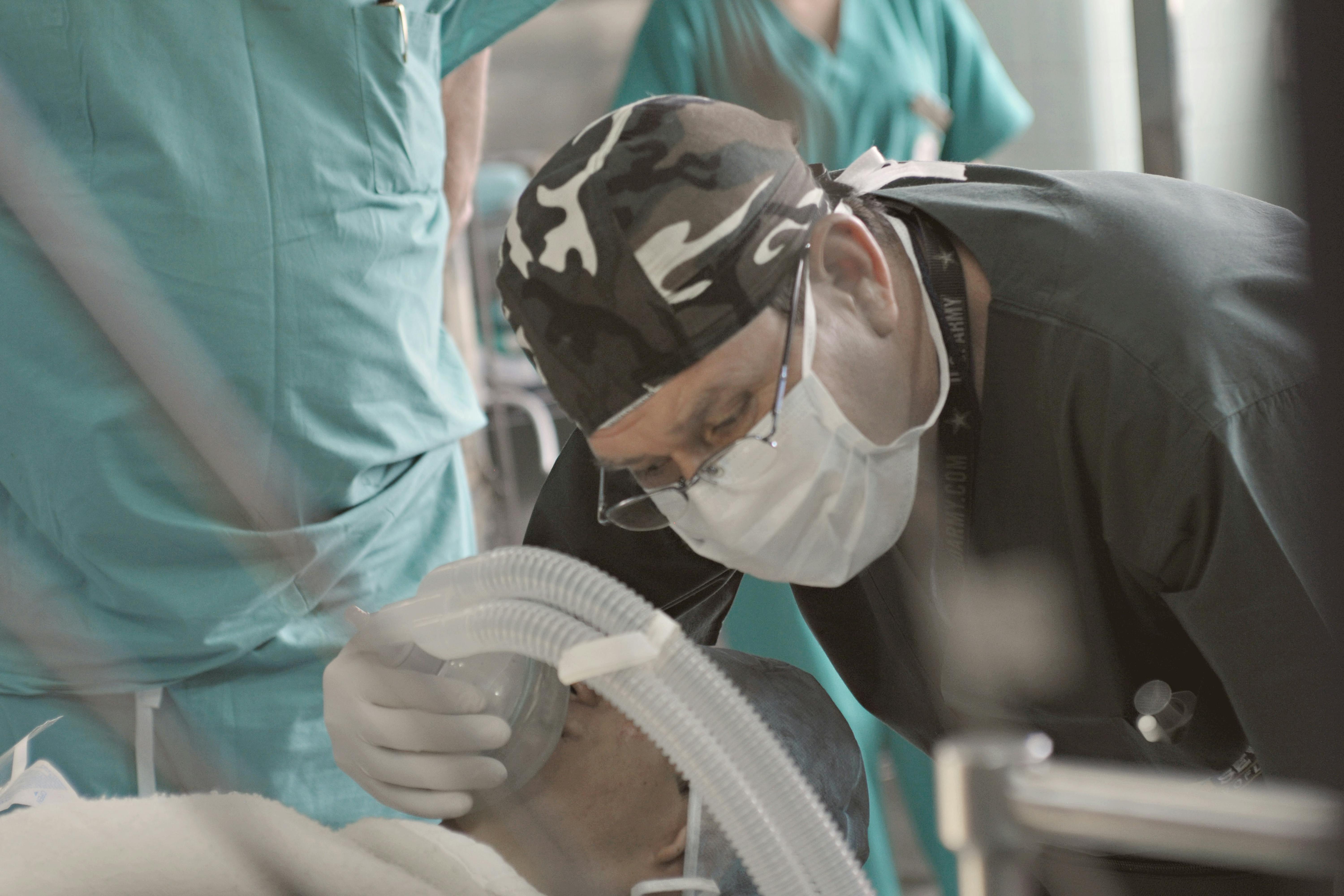 Gratis Medici e infermieri assistono un paziente durante una procedura medica al chiuso. Foto a disposizione