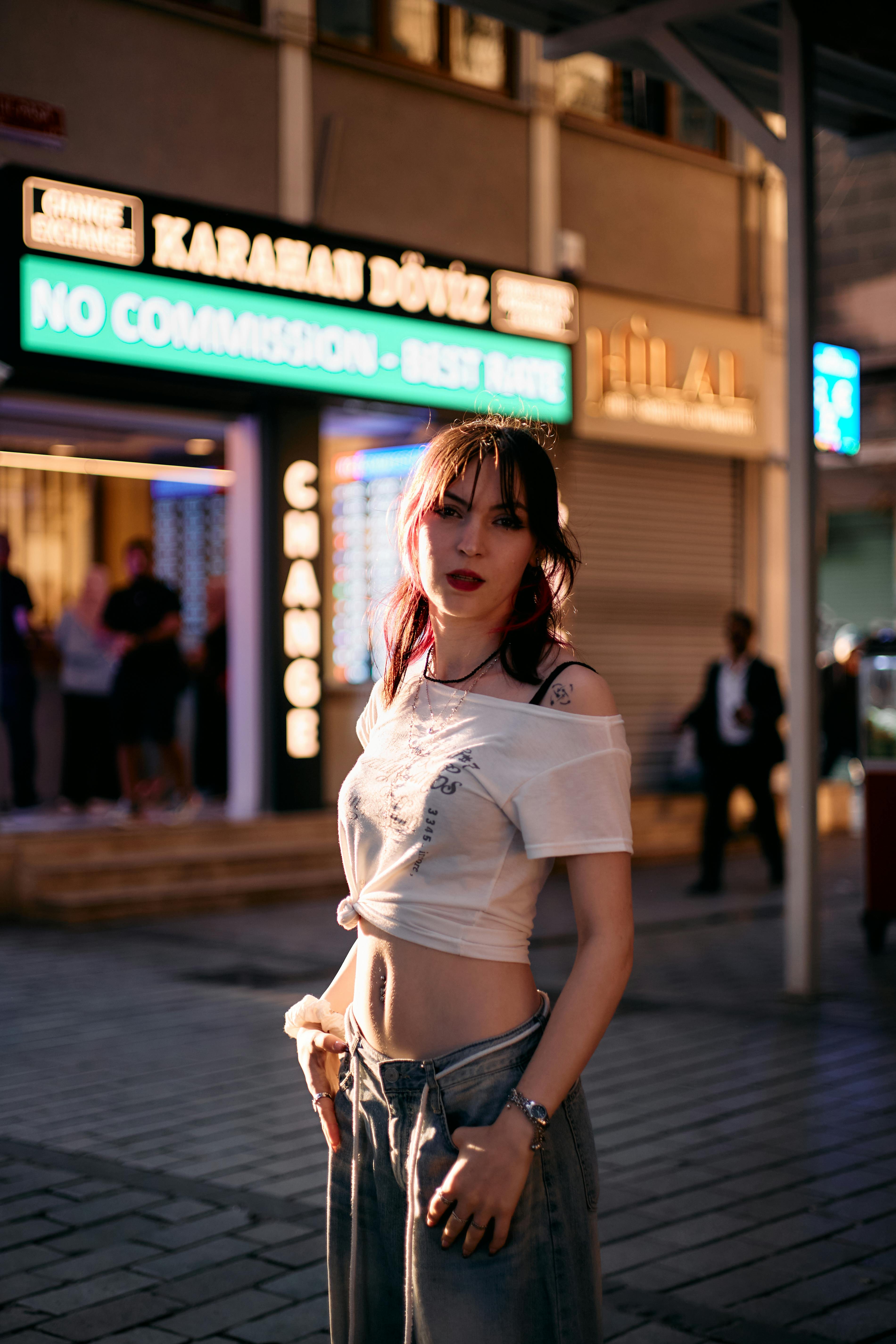 Young woman posing on a vibrant evening street in İstanbul, Türkiye. Urban atmosphere.