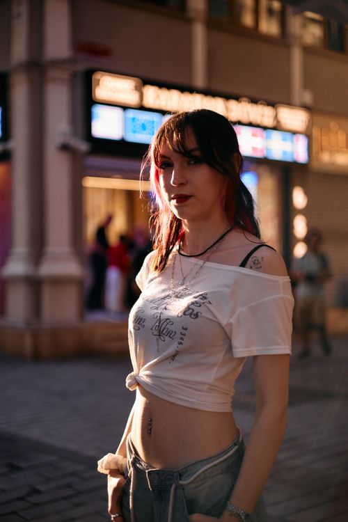 Free A stylish young woman poses on a bustling street in Istanbul during sunset, capturing the city's urban vibe. Stock Photo