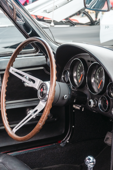 Interior view of a classic 1960s American car dashboard featuring vintage gauges and retro design.