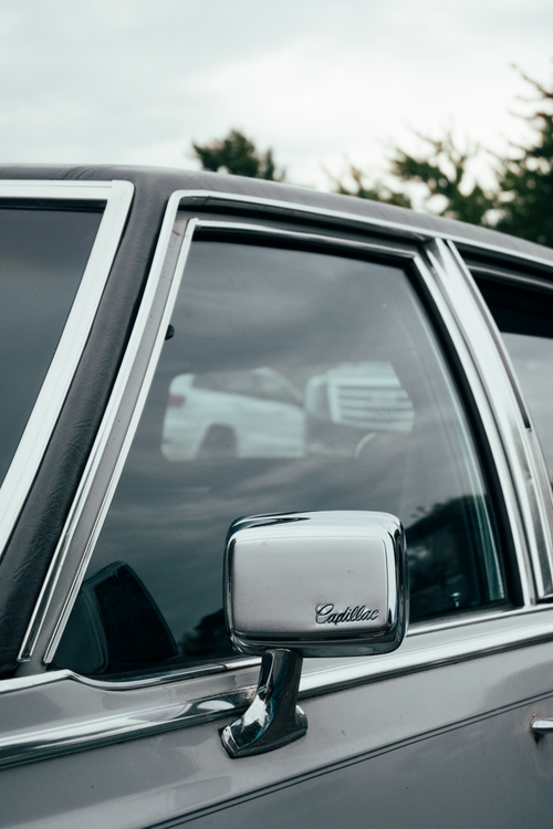 Free Close-up of a Cadillac car showcasing its vintage mirror and window details in Alto, Michigan. Stock Photo