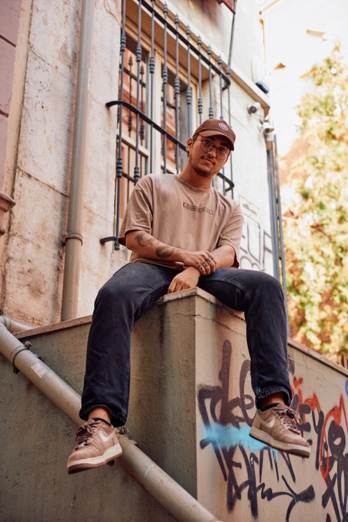 Free Trendy young adult poses against graffiti in İstanbul's vibrant streetscape. Stock Photo