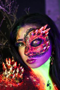 Captivating portrait of a fantasy creature with neon makeup and mask. Perfect for Halloween themes.