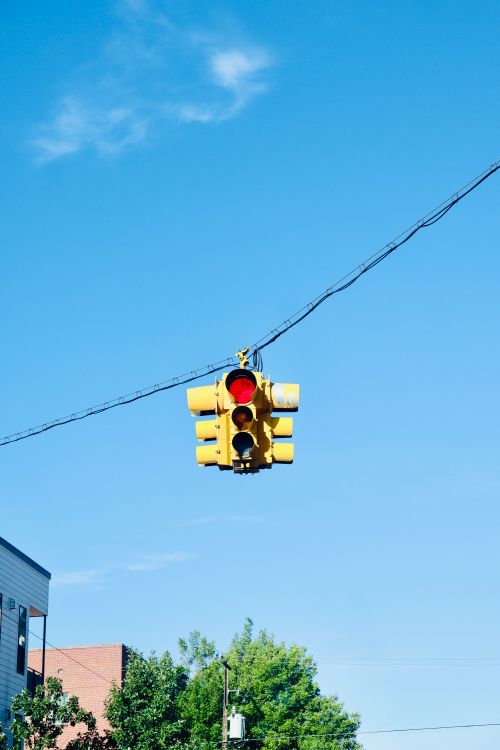 Free Traffic light suspended in the sky on a clear day in an urban area. Stock Photo
