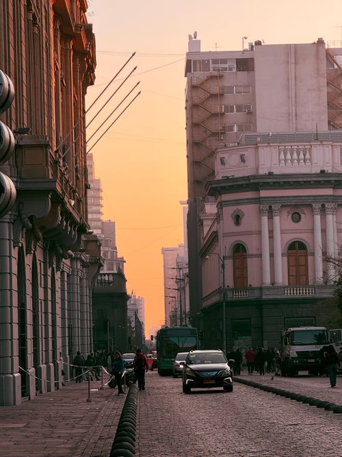 Free A bustling street with historic buildings at sunset, capturing the city's essence. Stock Photo