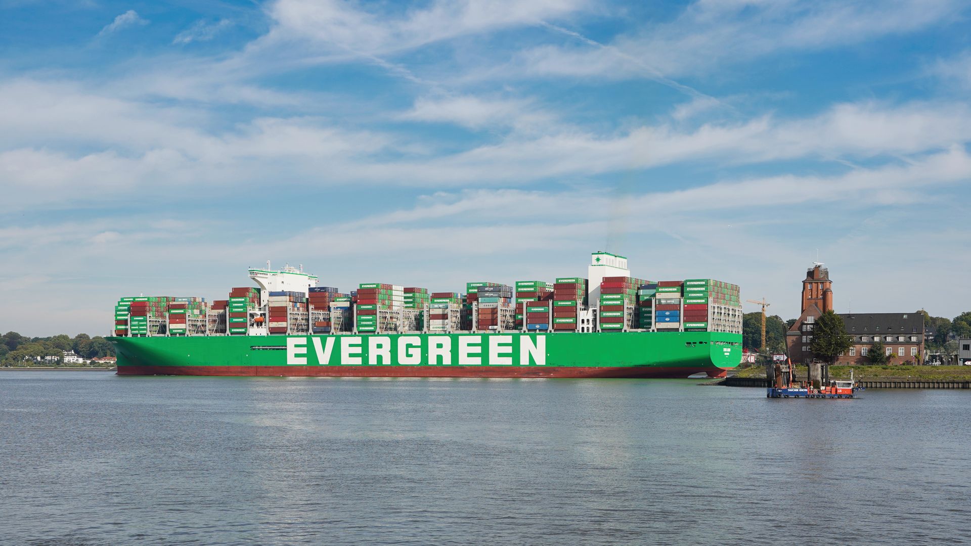 A large Evergreen container ship docked at Hamburg port, showcasing global commerce on a sunny day.