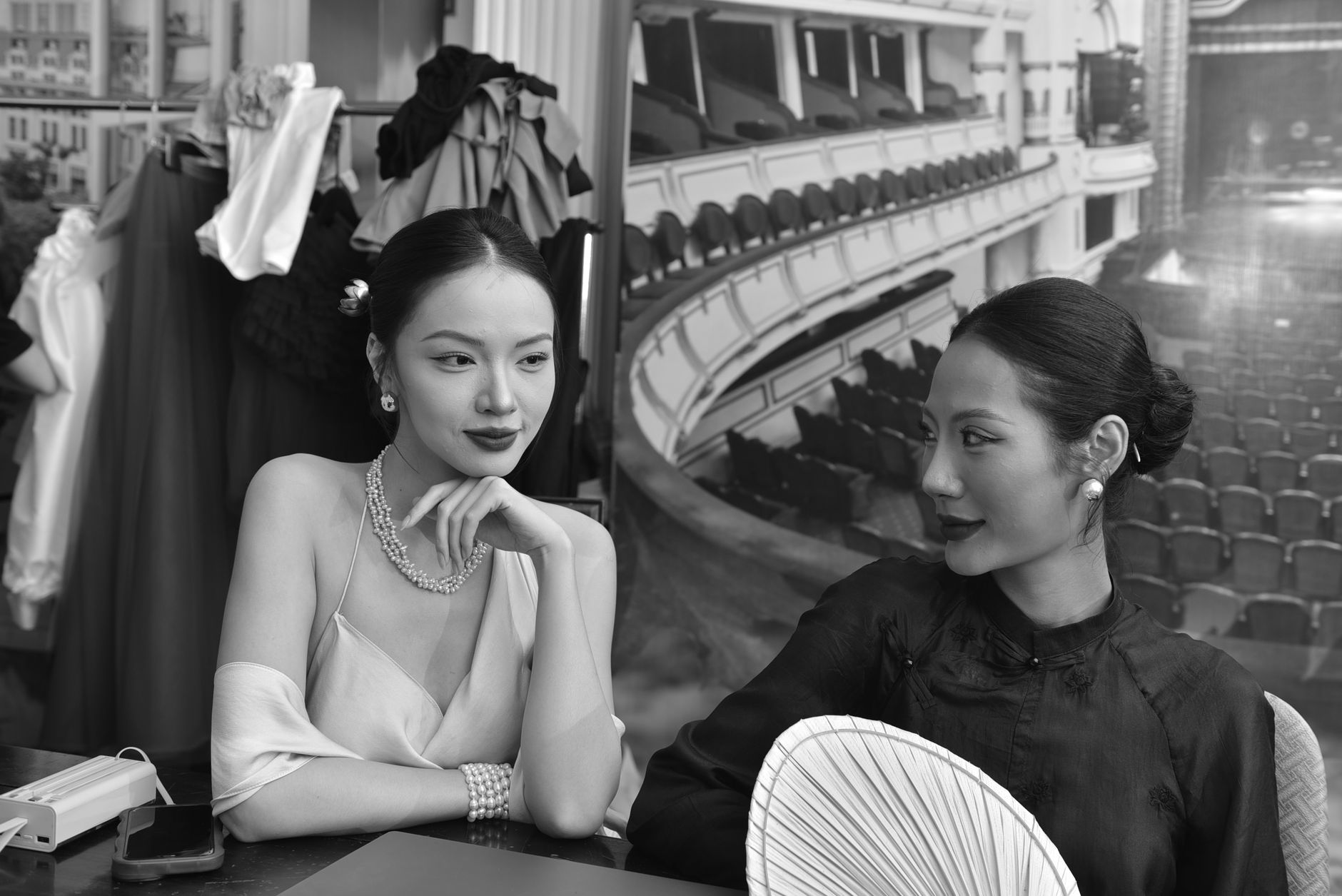 Two people in an elegant setting, mid-conversation, attention turned fully toward each other.