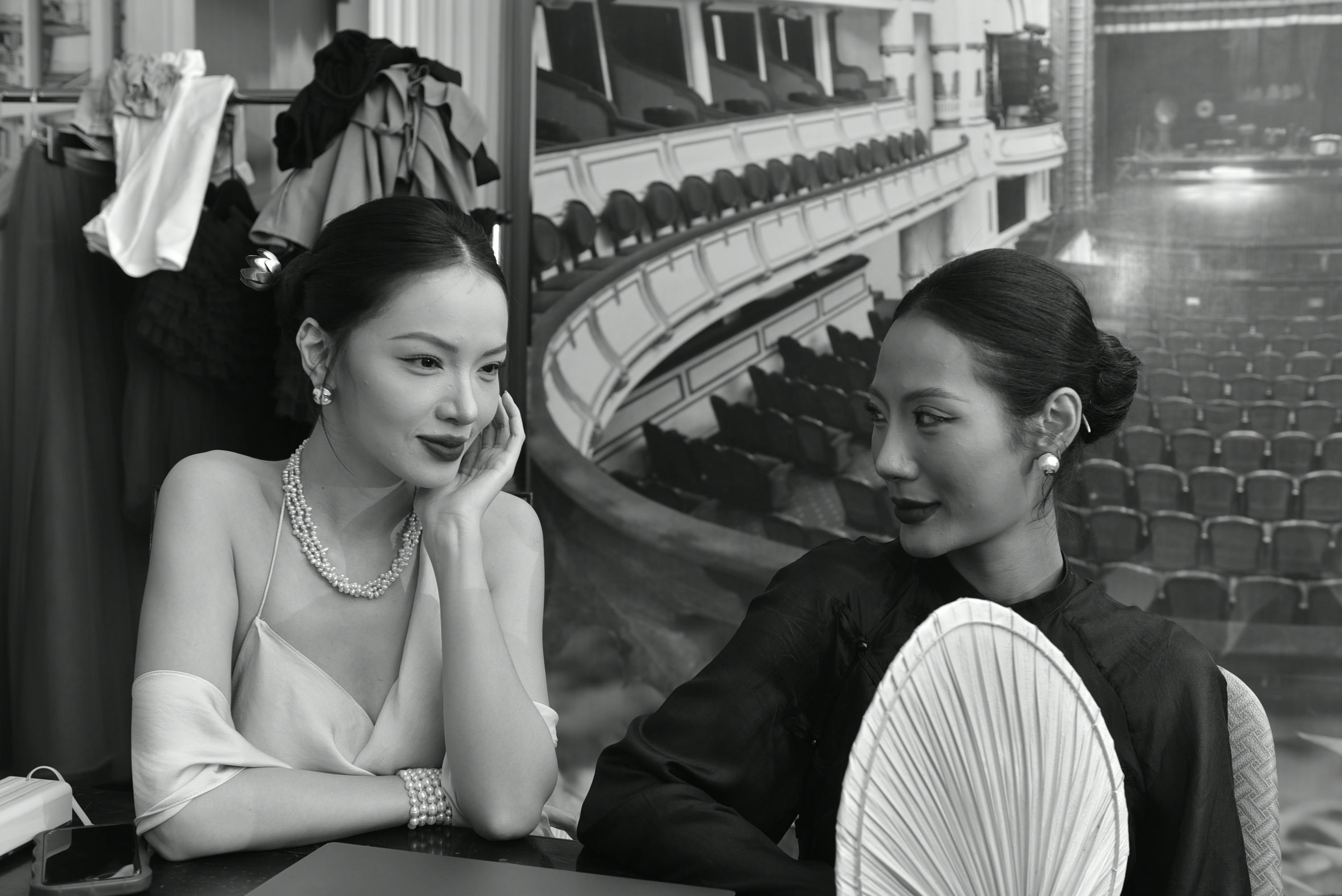 Free Two elegantly dressed women engage in conversation backstage, capturing a theatrical ambiance. Stock Photo