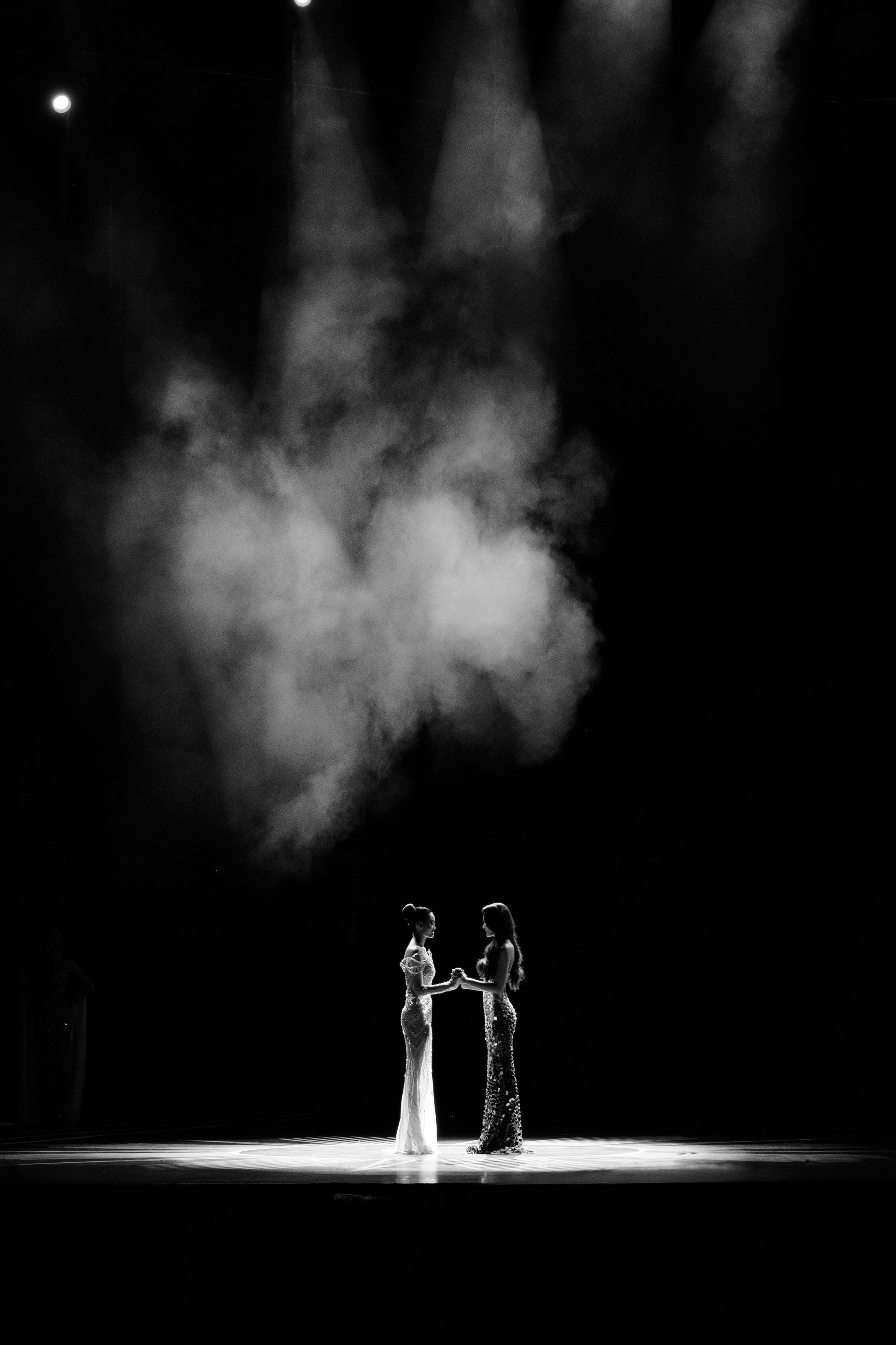 Free Two women perform a graceful dance on a spotlighted stage in dramatic black and white. Stock Photo