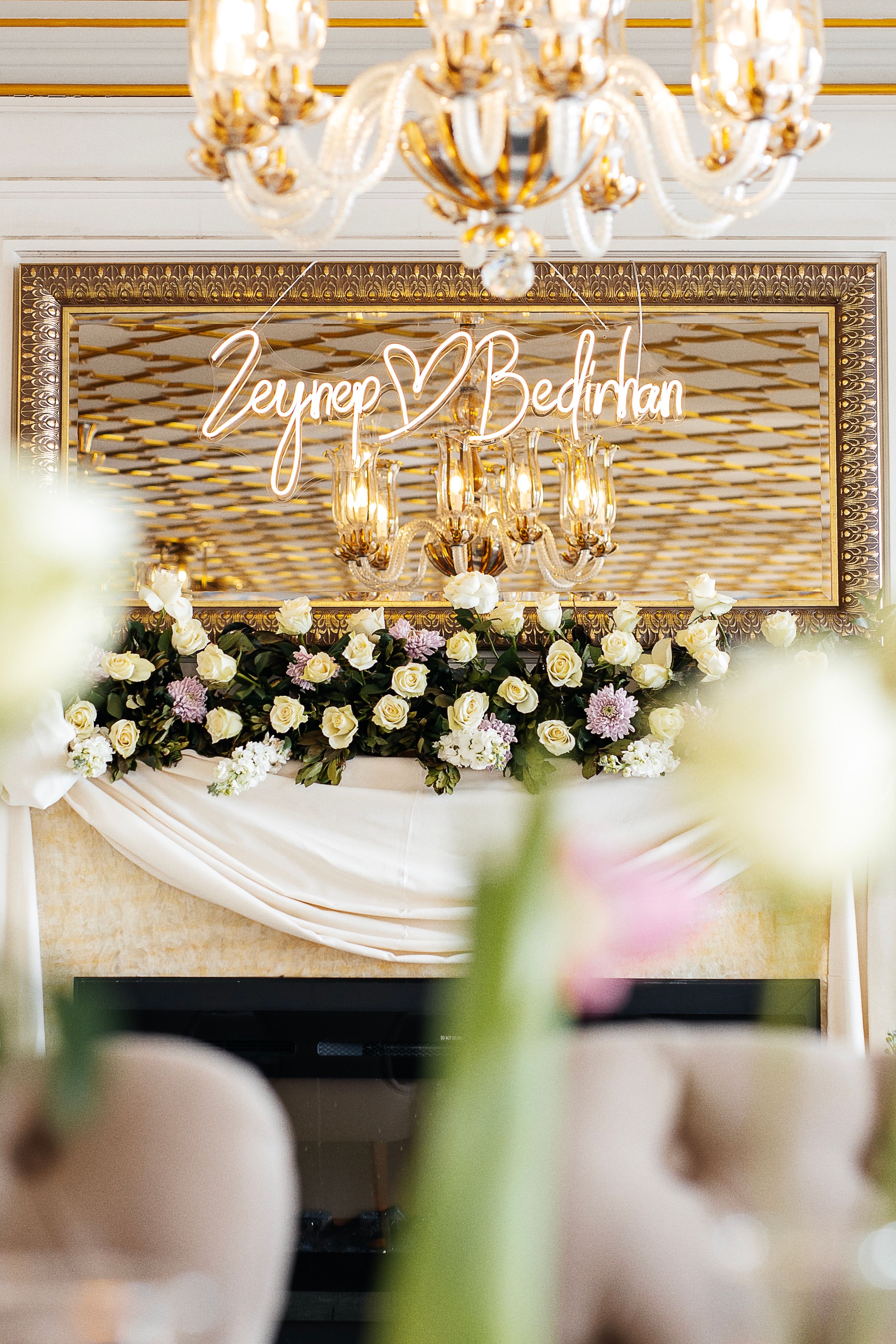 Luxurious wedding venue featuring chandelier and floral decorations with personalized touch.