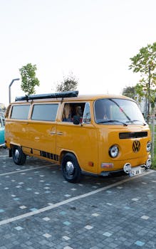 Classic yellow Volkswagen van parked outdoors on a sunny day.