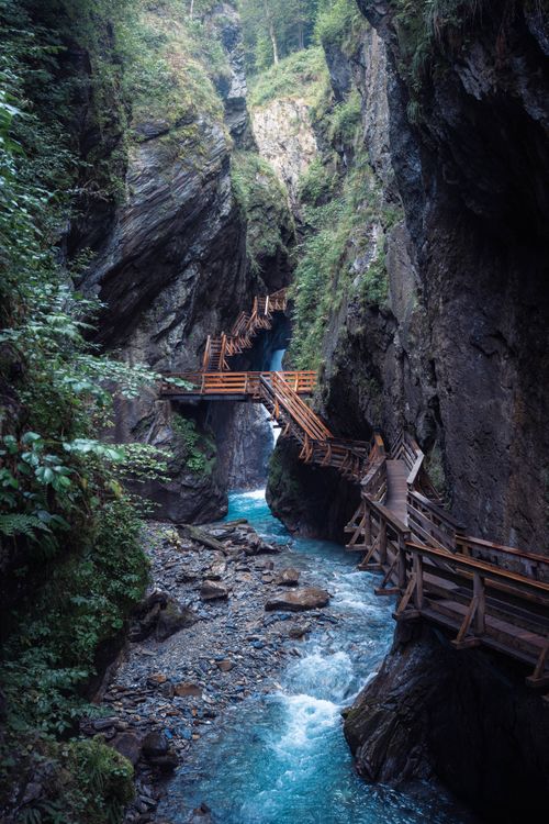 Free Wooden walkway through a picturesque mountain gorge with a flowing stream. Stock Photo